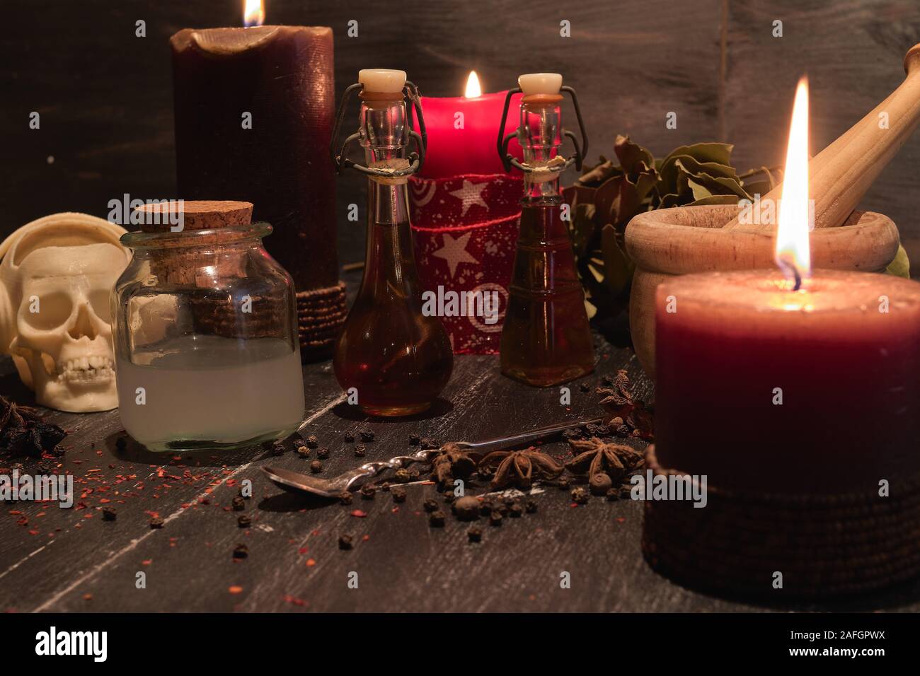 Pozione di erbe naturali di magia nera, con mortaio, teschi e candele Foto Stock
