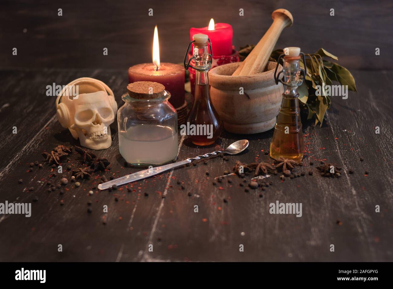 Pozione di erbe naturali di magia nera, con mortaio, teschi e candele Foto Stock