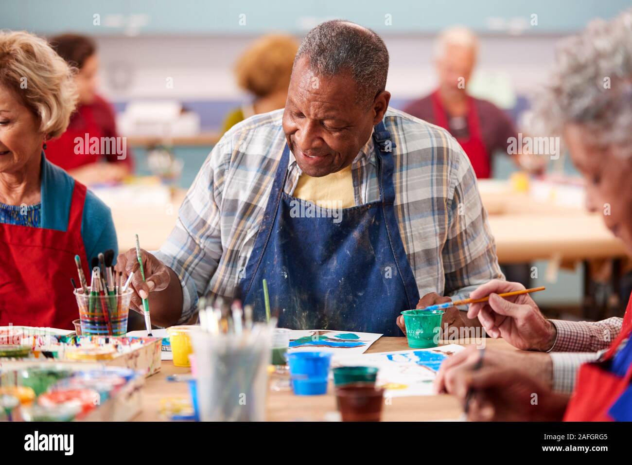 Senior pensionati uomo frequentando arte classe nel centro comunitario Foto Stock