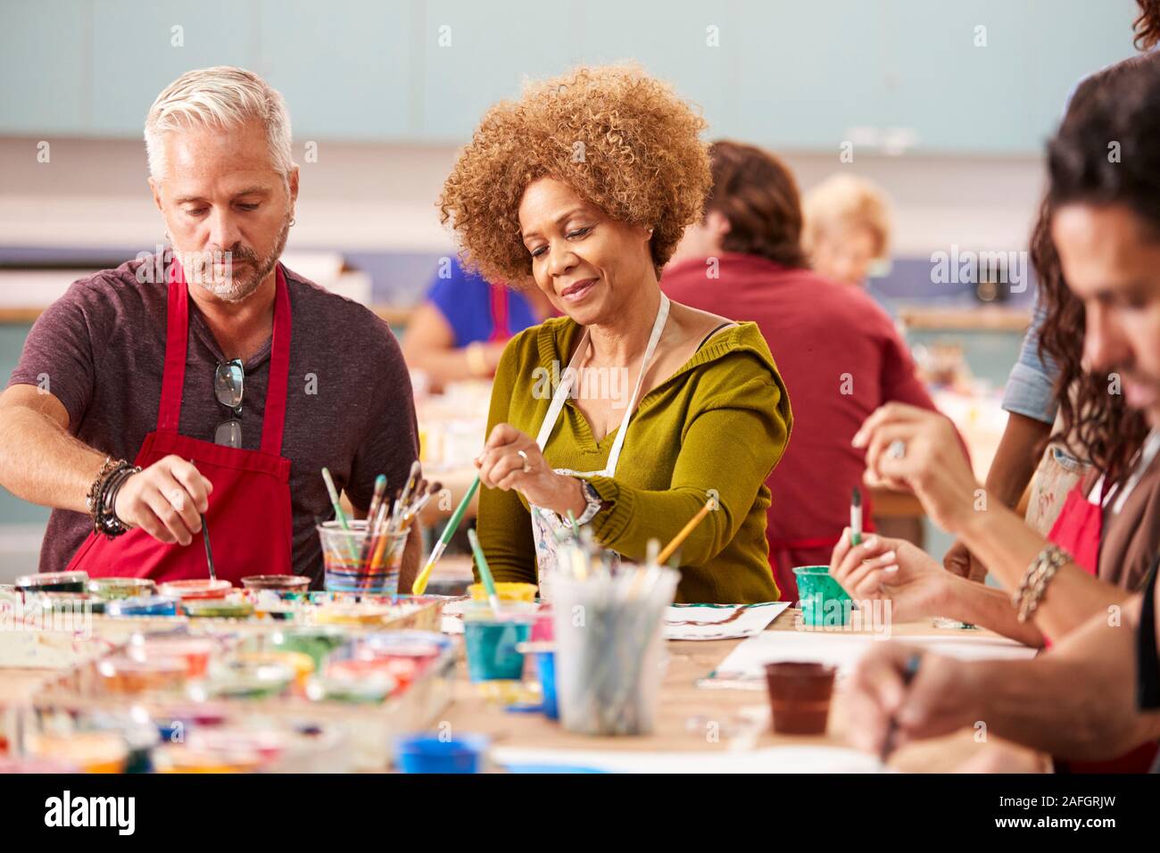 Gruppo di adulti maturi che frequentano la classe d'arte nel centro comunitario Foto Stock