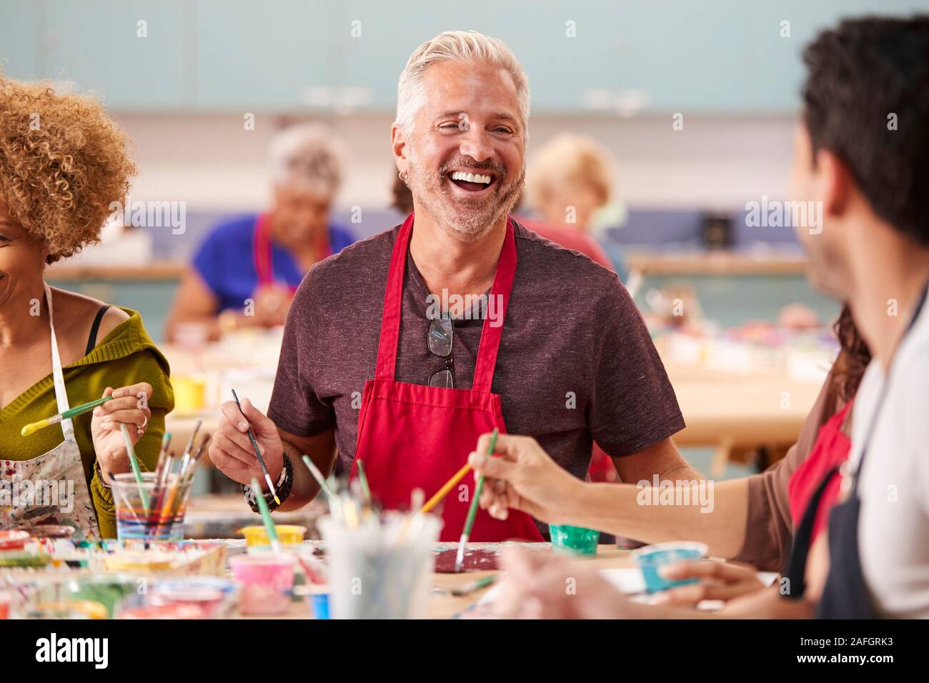 Gruppo di adulti maturi che frequentano la classe d'arte nel centro comunitario Foto Stock