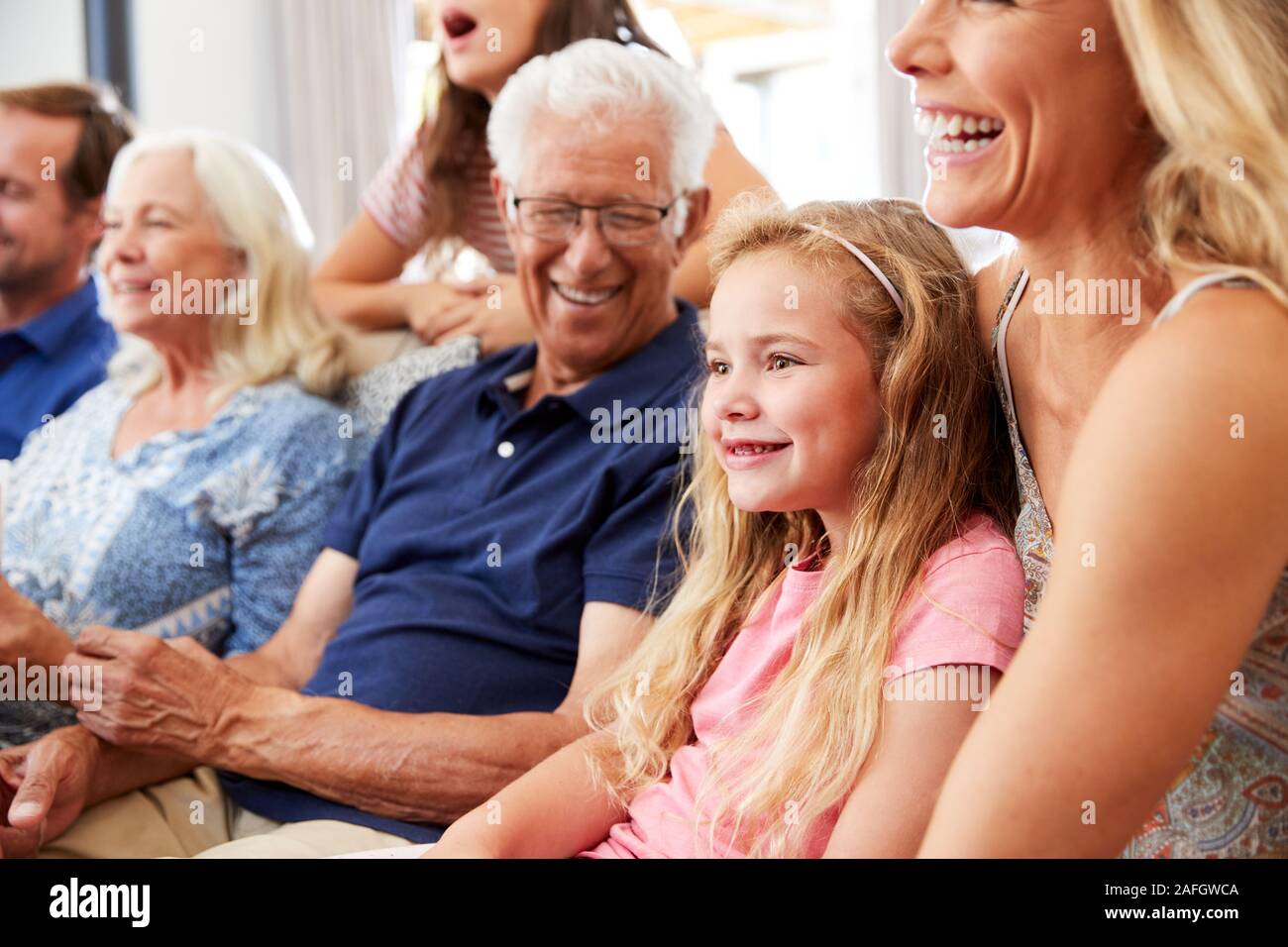 Famiglia Multi-Generation seduti sul divano a casa a guardare il filmato insieme Foto Stock