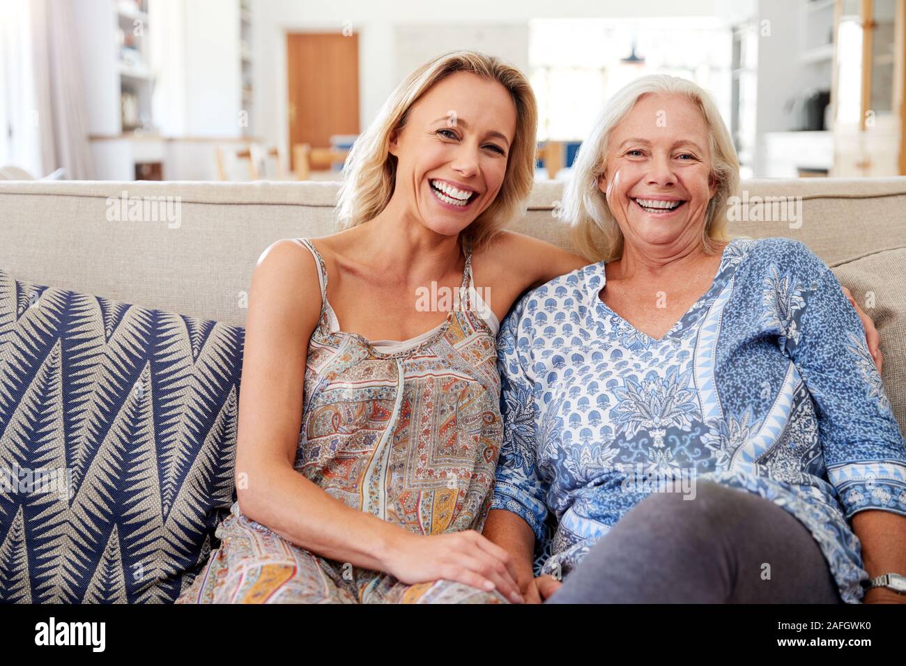 Ritratto di Madre sorridente con la figlia adulta rilassante sul divano di casa Foto Stock