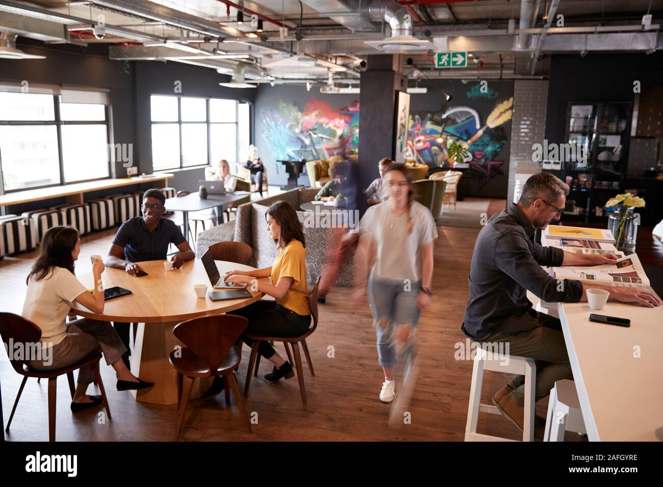 I Creative il lavoro e il relax nel loro ufficio zona mensa Foto Stock