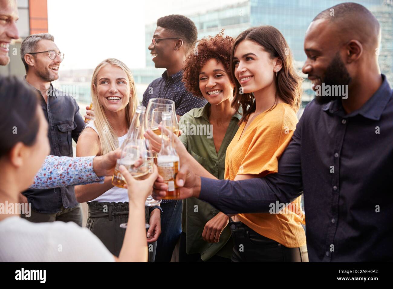 Azienda creativa ai colleghi il sollevamento vetri e fare un brindisi con drink dopo il lavoro Foto Stock
