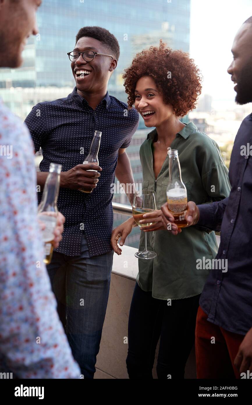 Sorridente azienda creativa ai colleghi di socializzare con drink dopo il lavoro, verticale Foto Stock