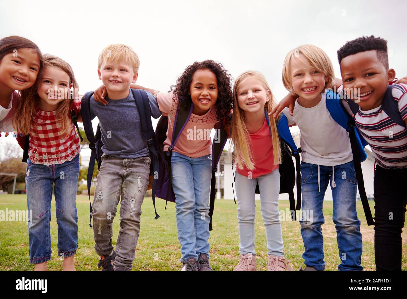 Ritratto di eccitato Scuola Elementare alunni sul campo da gioco in pausa Foto Stock