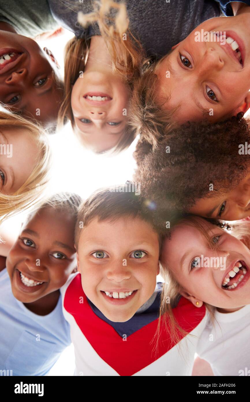Gruppo multiculturale dei bambini con gli amici guardando giù nella fotocamera Foto Stock