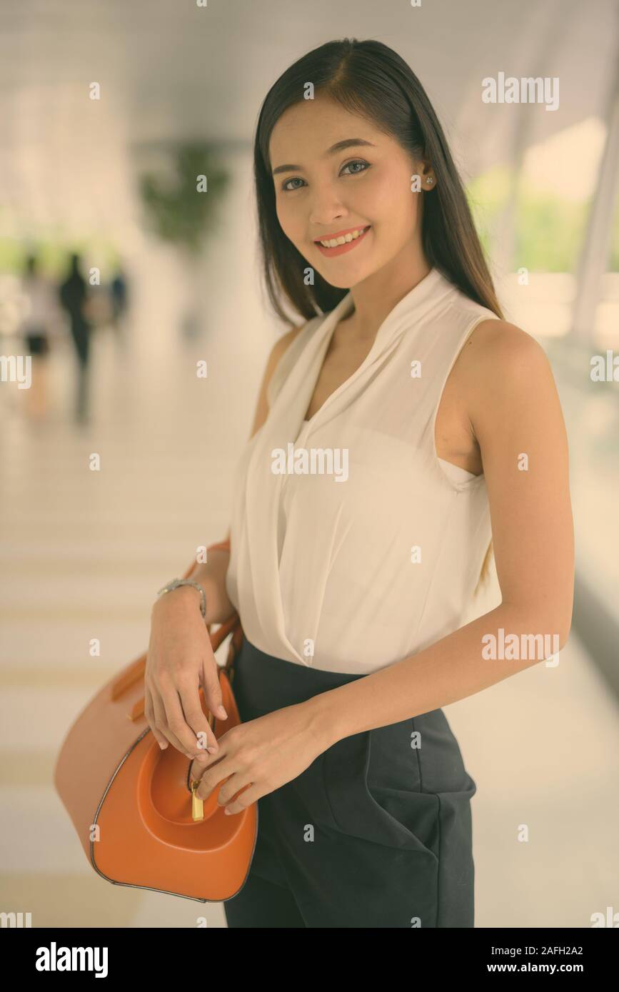 Giovane bella asiatica imprenditrice appendere fuori a la passerella Foto Stock