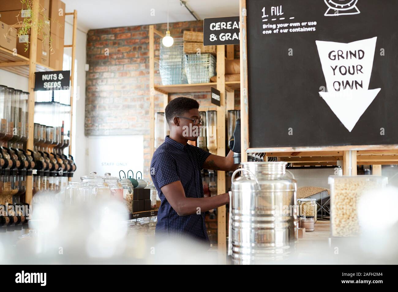 L'uomo l'acquisto di cereali e grani in plastica sostenibile libera Fruttivendolo Foto Stock