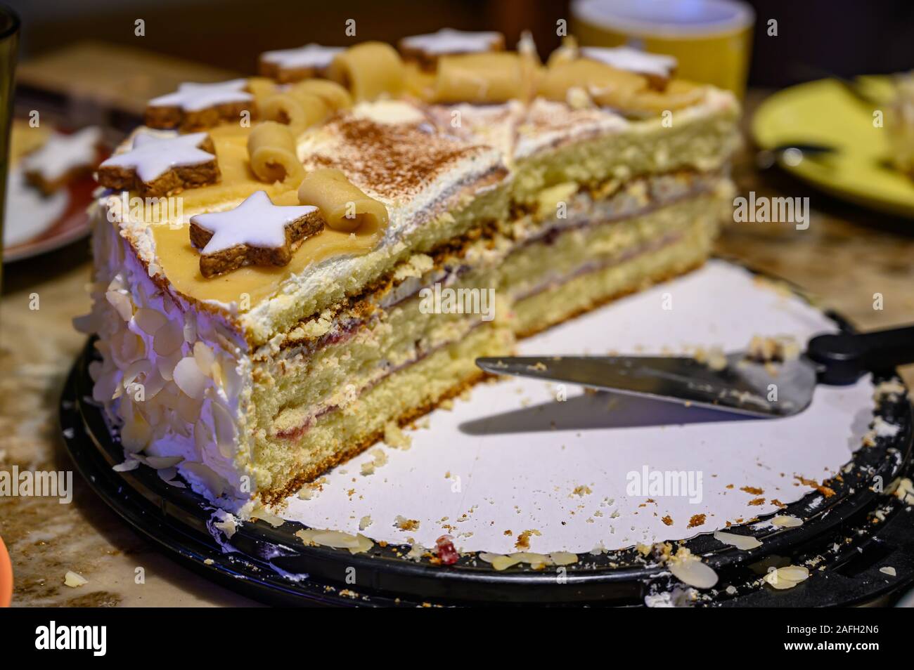 Primo piano di una torta multistrato con decorazioni su un piatto con un server torta su di esso Foto Stock