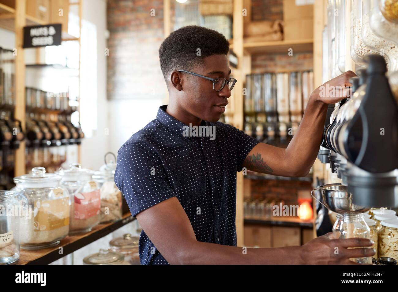 L'uomo l'acquisto di cereali e grani in plastica sostenibile libera Fruttivendolo Foto Stock