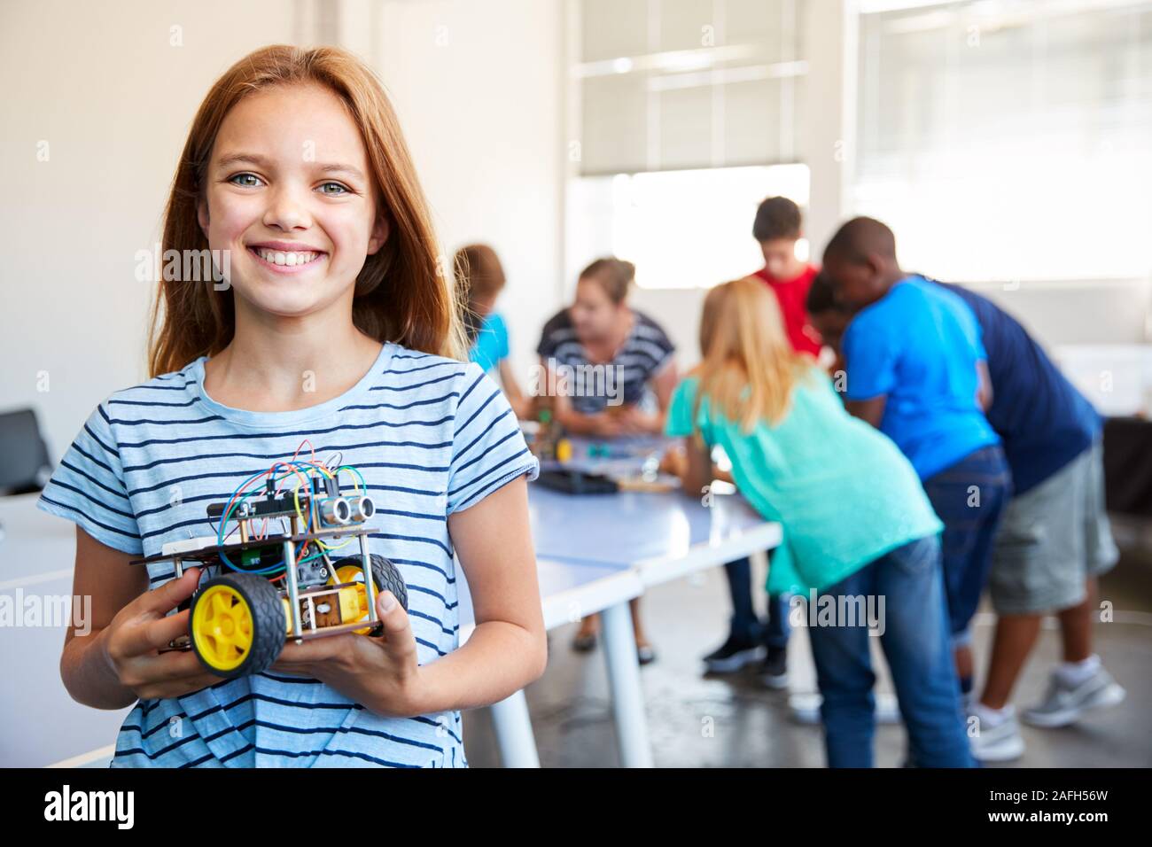 Ritratto di donna studente la costruzione di un veicolo robot Nel dopo scuola di computer di classe di codifica Foto Stock