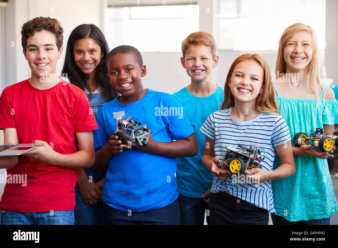 Ritratto di studenti maschi e femmine la costruzione di un veicolo robot Nel dopo scuola di computer di classe di codifica Foto Stock