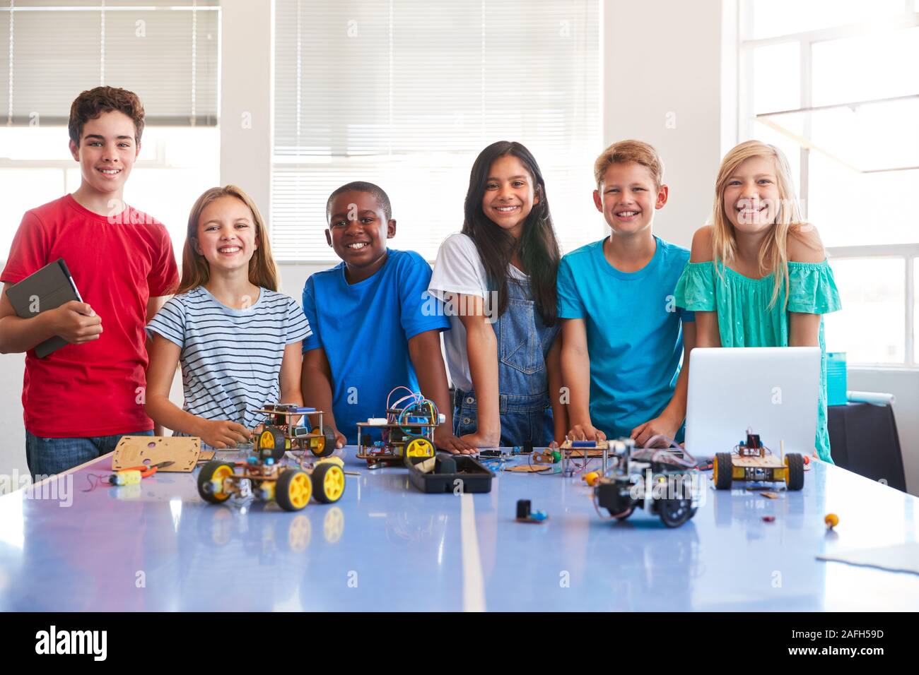 Ritratto di studenti maschi e femmine la costruzione di un veicolo robot Nel dopo scuola di computer di classe di codifica Foto Stock