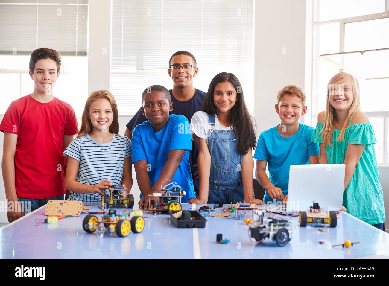 Ritratto di studenti con insegnante la costruzione di un veicolo robot Nel dopo scuola di computer di classe di codifica Foto Stock