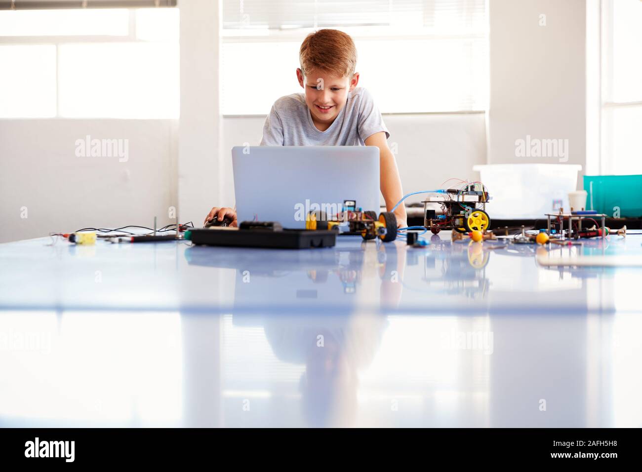 Maschio edificio dello studente e programmazione veicolo Robot nella Scuola di Computer di classe di codifica Foto Stock