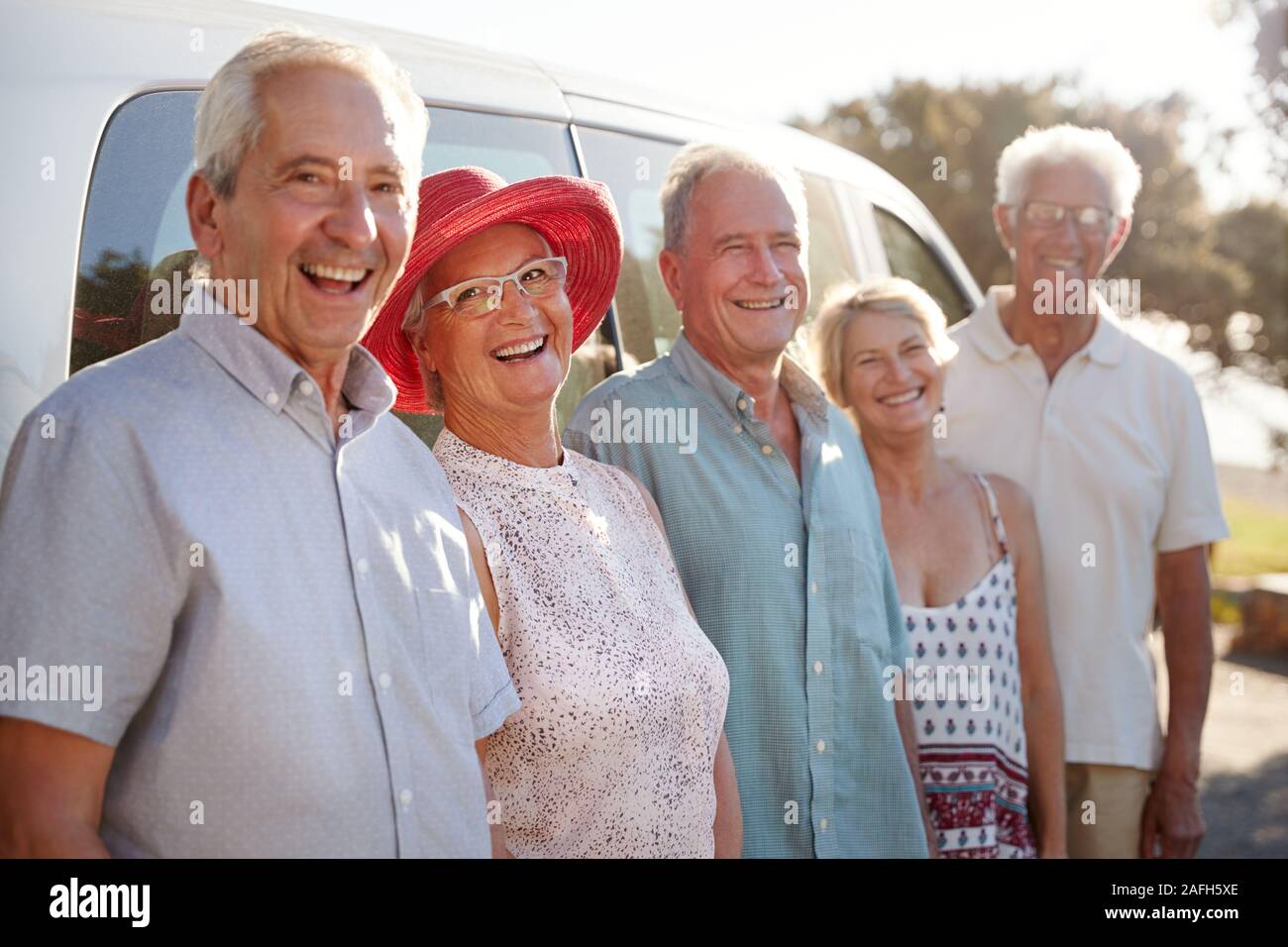 Ritratto di Senior amici insieme in piedi accanto a Van in vacanza Foto Stock