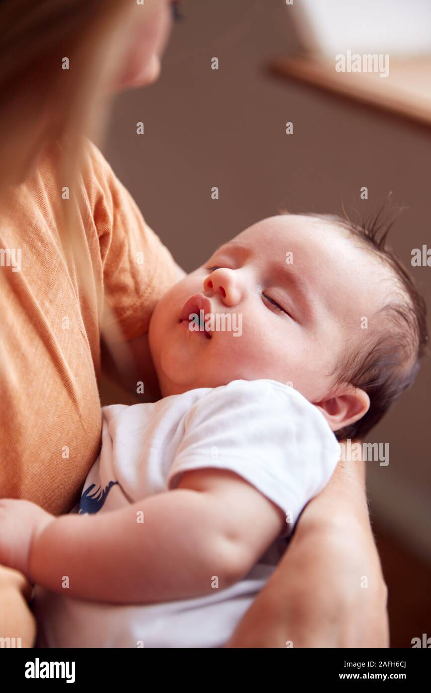 Madre Amorosa azienda neonato a casa In Appartamento Loft Foto Stock