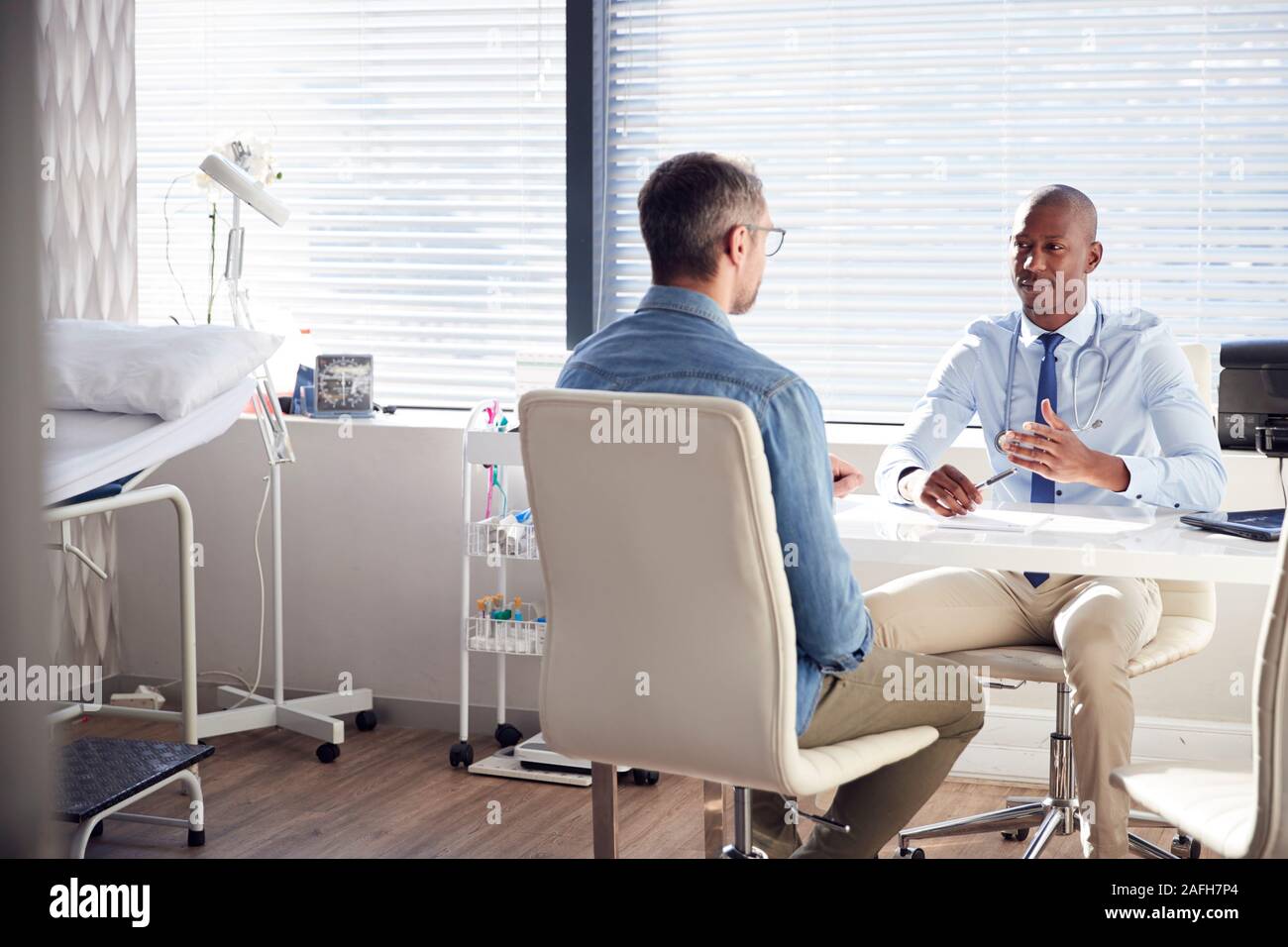 Maschio maturo paziente in consultazione con il medico in ufficio Foto Stock