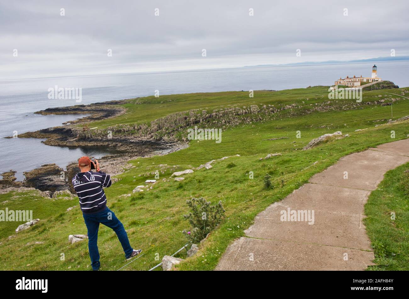 Fotografo di viaggio fotografando Neist Point e faro, Isola di Skye, Ebridi Interne, Scozia Foto Stock