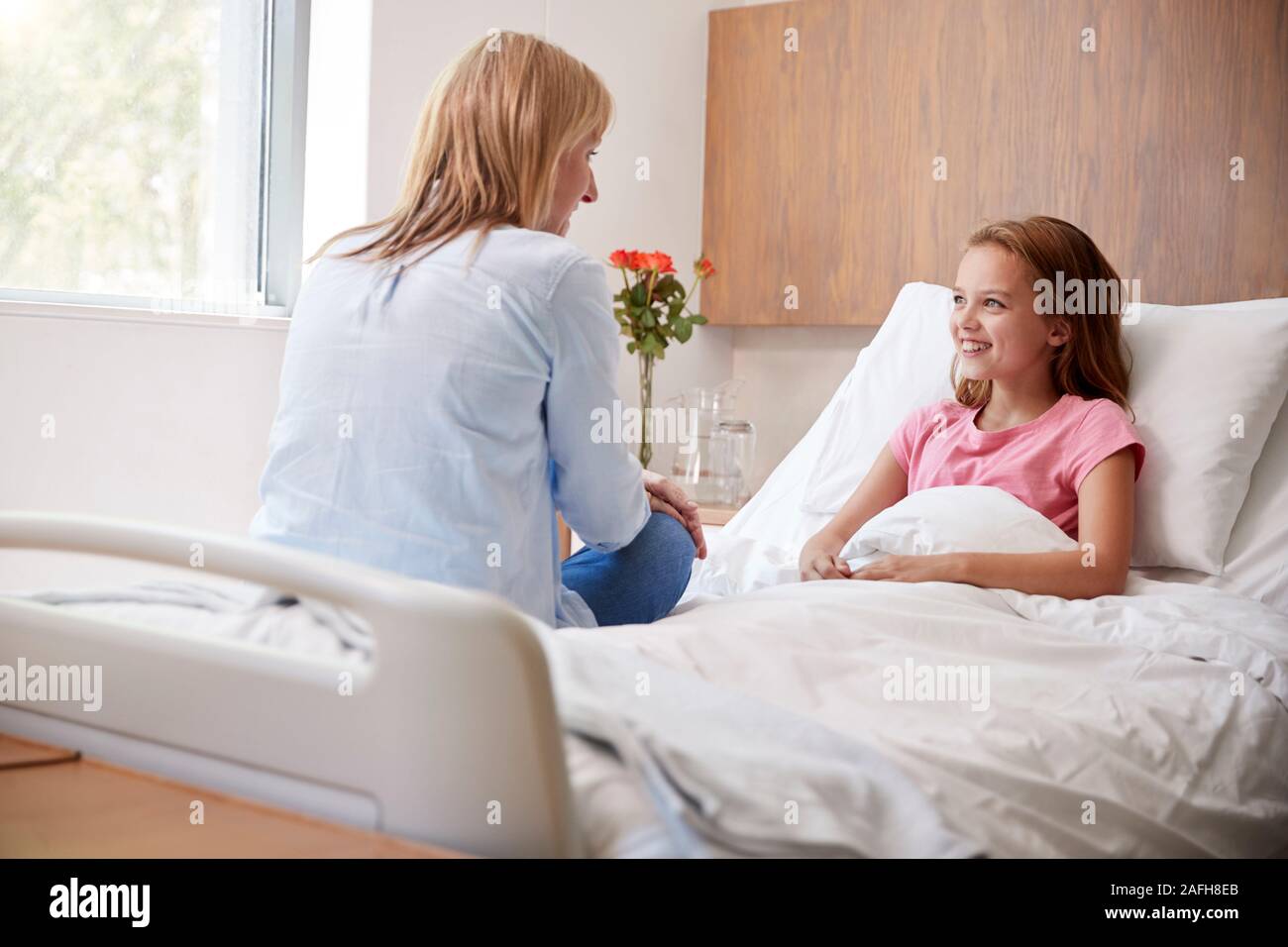 Madre figlia in visita a letto in ospedale Foto Stock