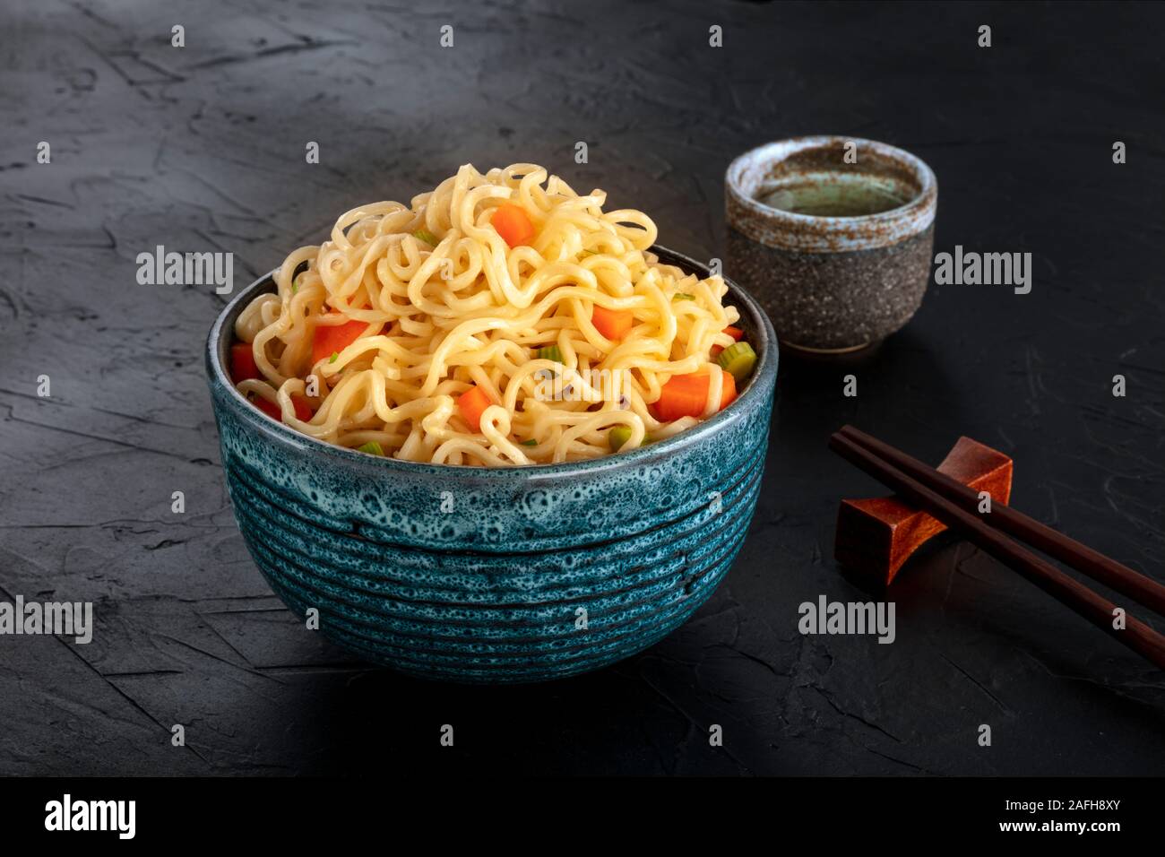 Tagliatelle istante con verdure, con amore e bastoncini, un close-up su sfondo scuro Foto Stock