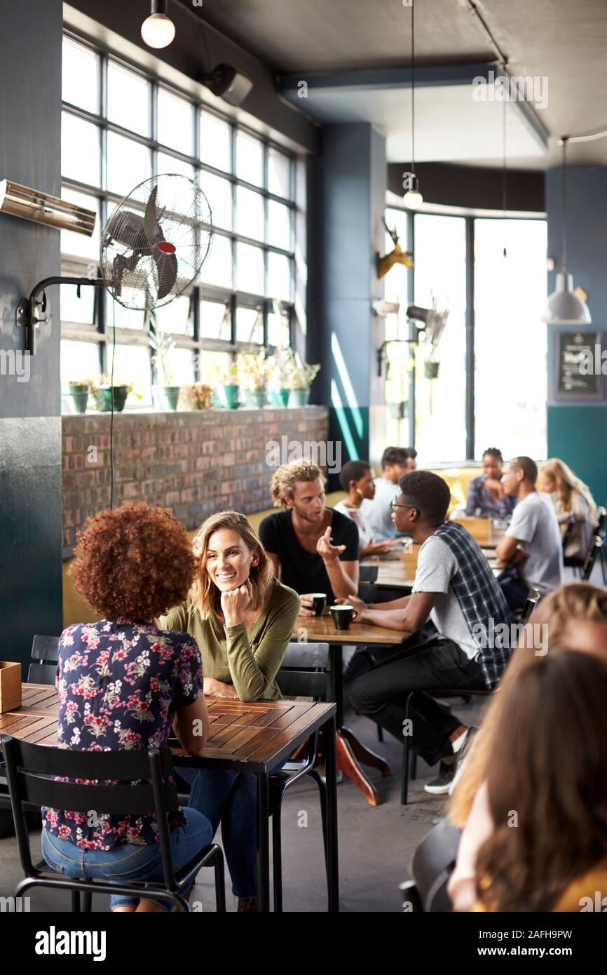 Interno occupato del Coffee Shop con i clienti seduti ai tavoli Foto Stock