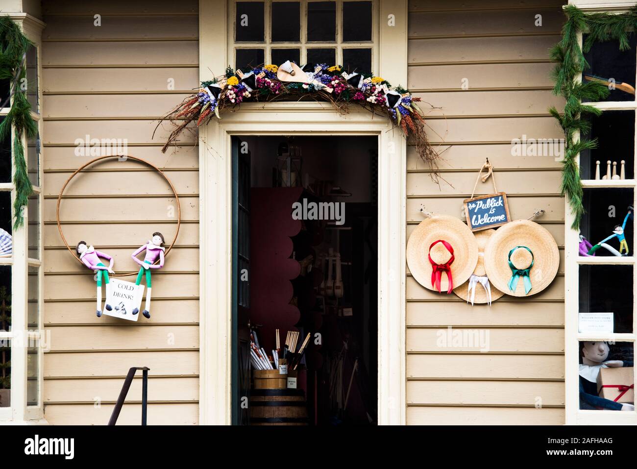 Ghirlanda di Natale oltre la porta aperta del William Pitt store, Colonial Williamsburg. Visibile merci comprendono Hotch Potch bambole, cappelli di paglia e bacchette. Foto Stock
