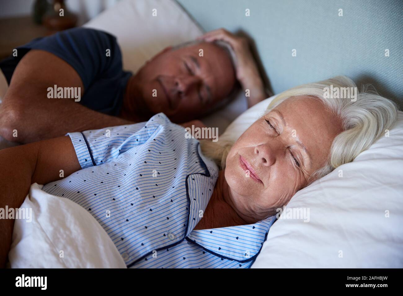 Senior coppia bianco dormendo nel loro letto, vita, close up Foto Stock