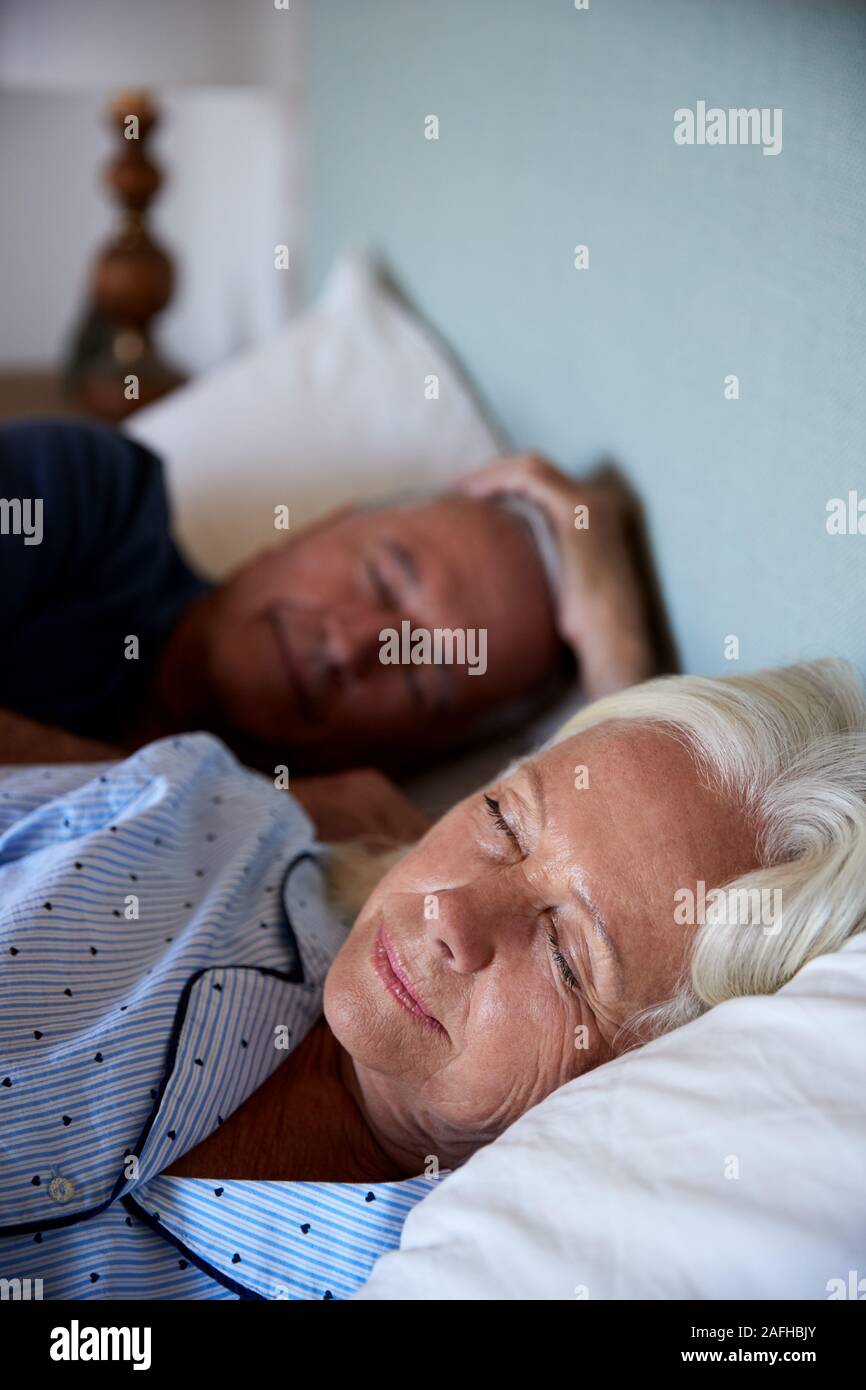 Senior bianco giovane addormentato nel loro letto, vita, close up, verticale Foto Stock