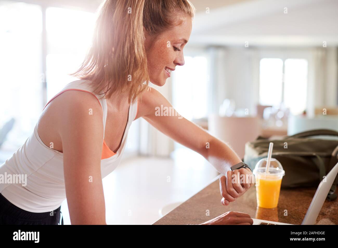 Millenaria donna bianca controllo app fitness sul suo smartwatch dopo un allenamento, vista laterale, vicino fino Foto Stock