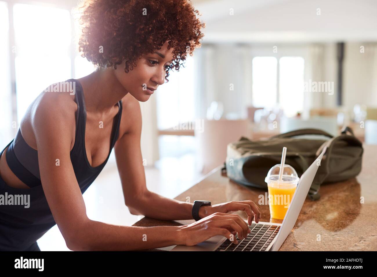 La millenaria americano africano donna controllo app fitness su laptop dopo allenamento, vista laterale Foto Stock