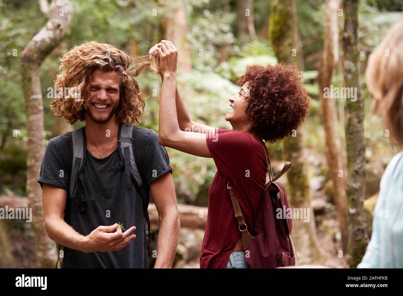 La millenaria americano africano donna prendendo le bave al di fuori del suo amico maschio i capelli, close up Foto Stock