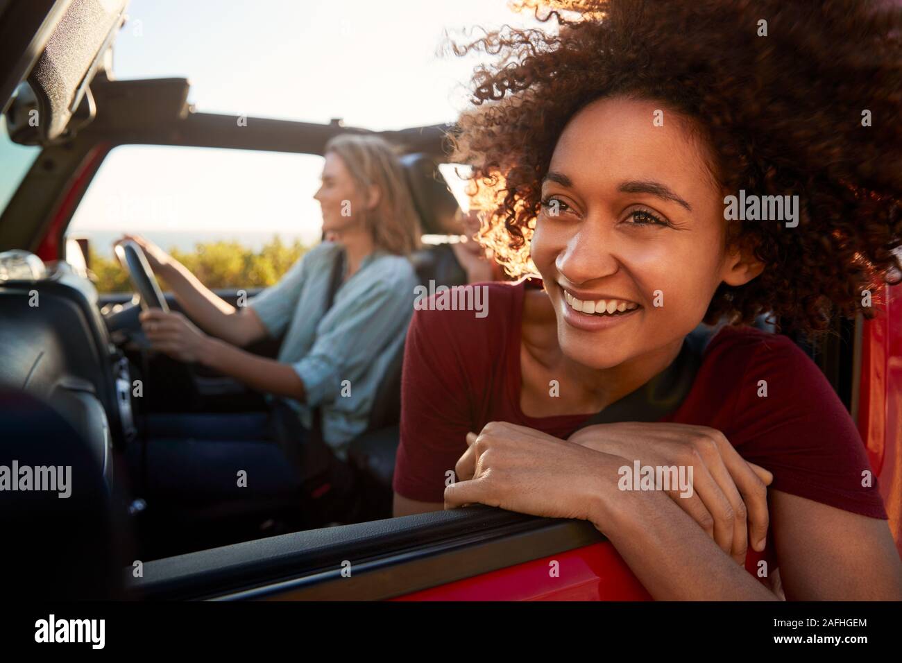 La millenaria americano africano donna su un viaggio con gli amici, proteso al di fuori della finestra di auto, close up Foto Stock