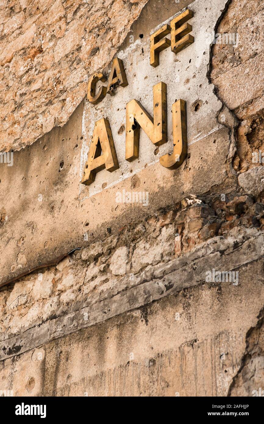 Mostar, Bosnia e Erzegovina, 13 Ottobre 2007: Un distrutto caffe segno su una parete di un edificio pieno di vecchi fori shrapnel a Mostar, Bosnia e Foto Stock