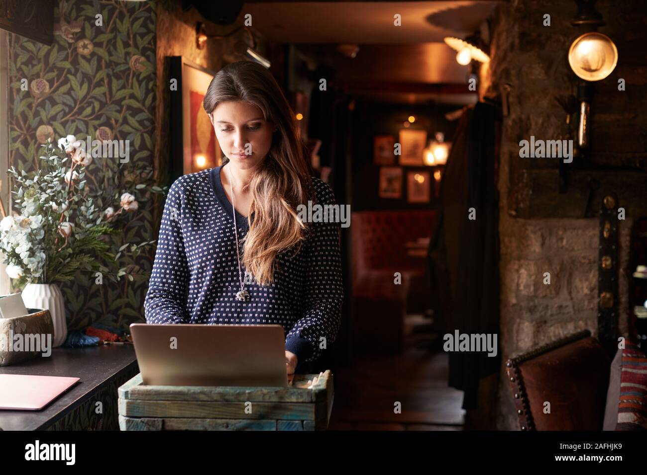 Addetta alla ricezione funzionante sul computer portatile presso Hotel Check In Foto Stock