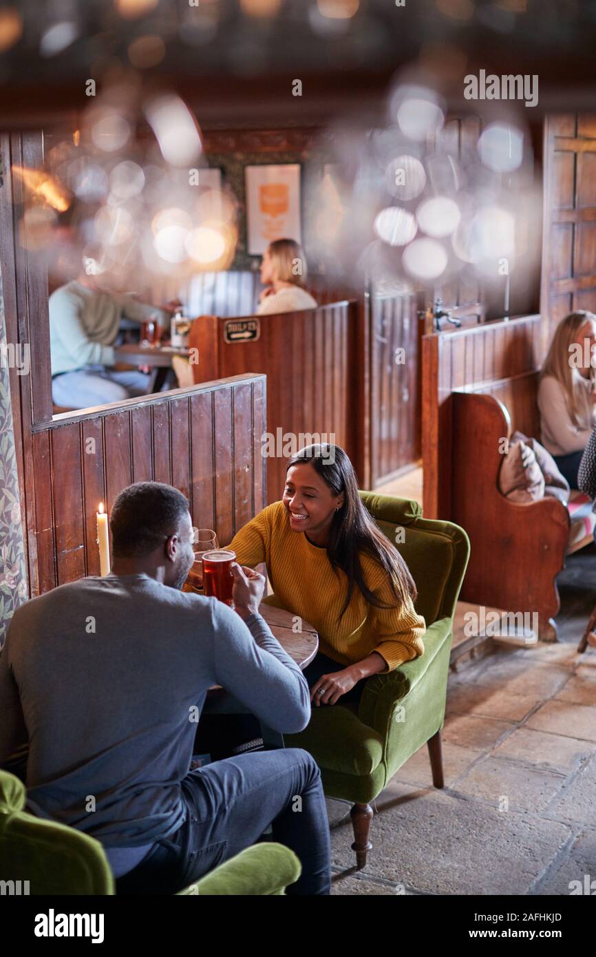 Due sale riunioni per pranzo bevande nel tradizionale Pub Inglese facendo un brindisi Foto Stock