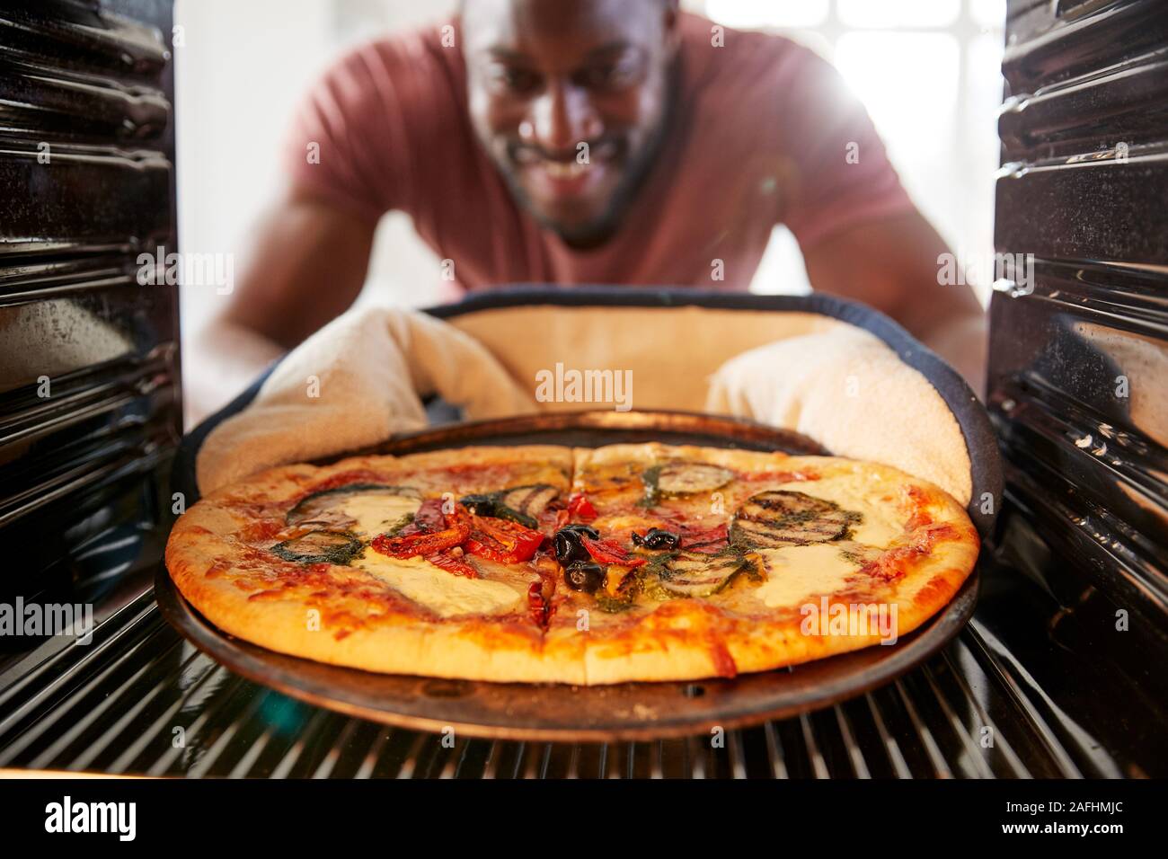 Vista guardando fuori dall'interno del forno come uomo cuochi Pizza Fresca Foto Stock