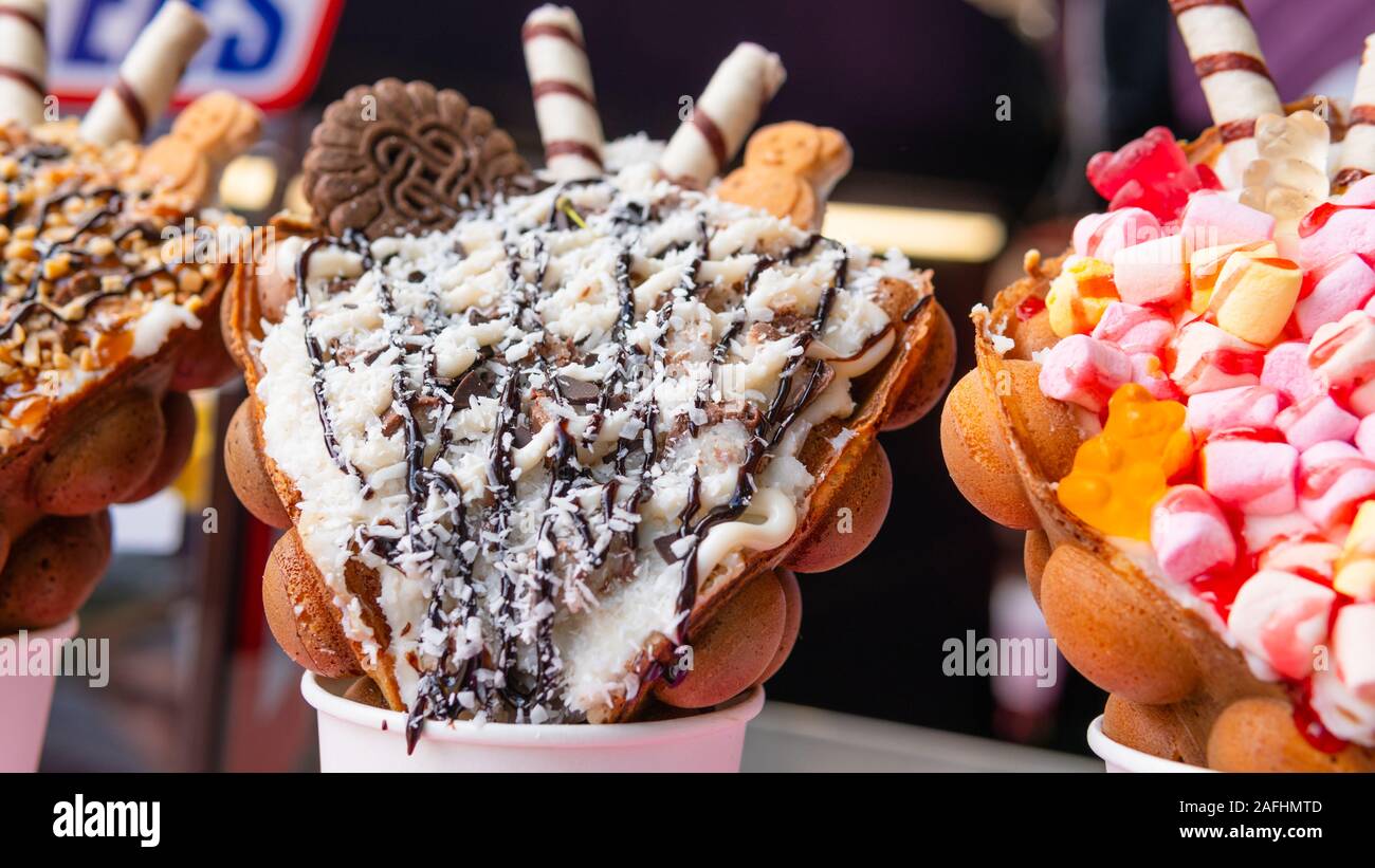 Bubble cialde con lamponi, cioccolato e marshmallow bianco in bicchieri di carta sono venduti su cucina aperta food festival evento. Hong kong cialde. Concep Foto Stock