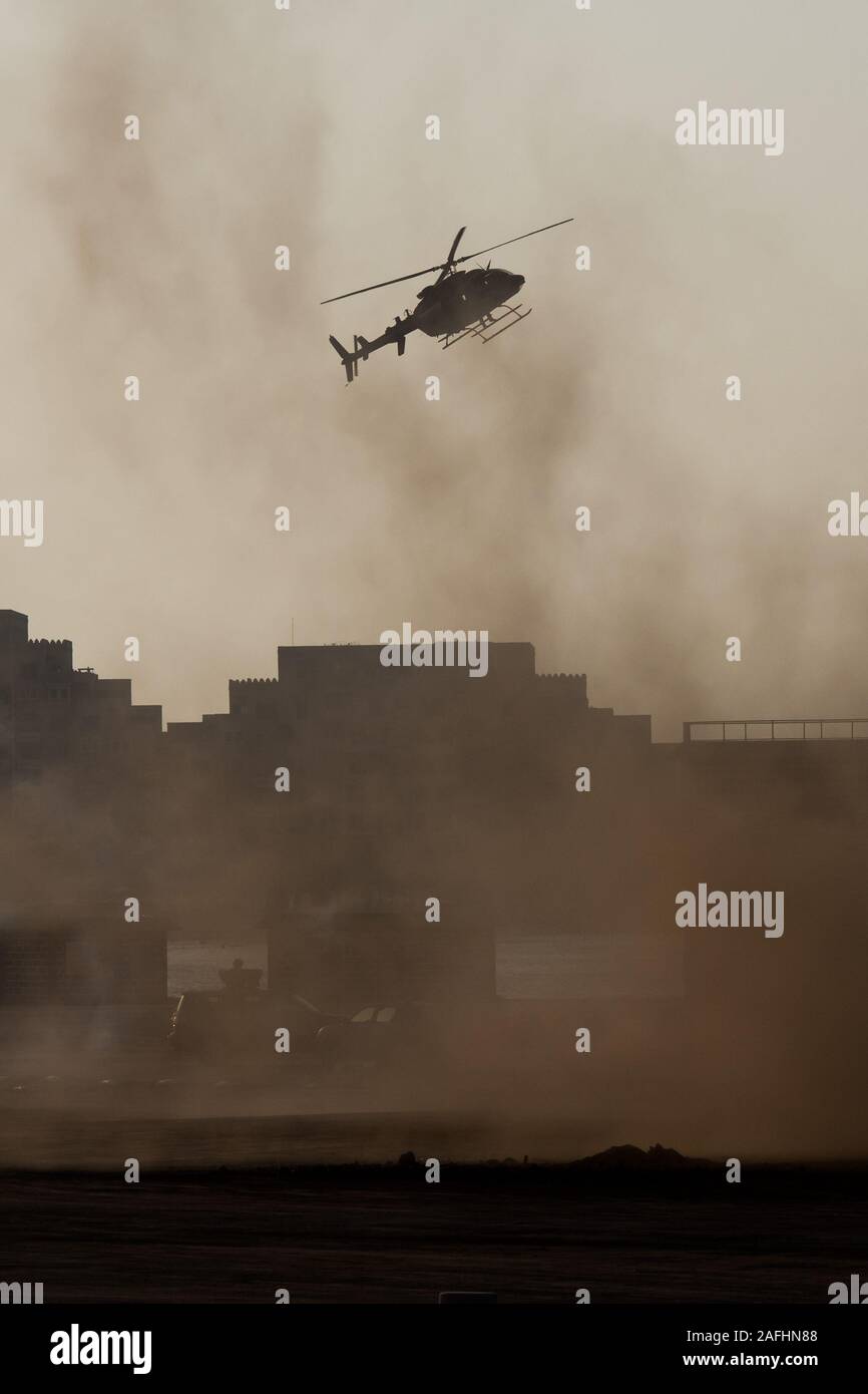 Combattimento militare e della guerra con un elicottero che vola nel caos e distruzione. Concetto militare di potenza, forza, resistenza, air raid. Visualizzazione verticale Foto Stock