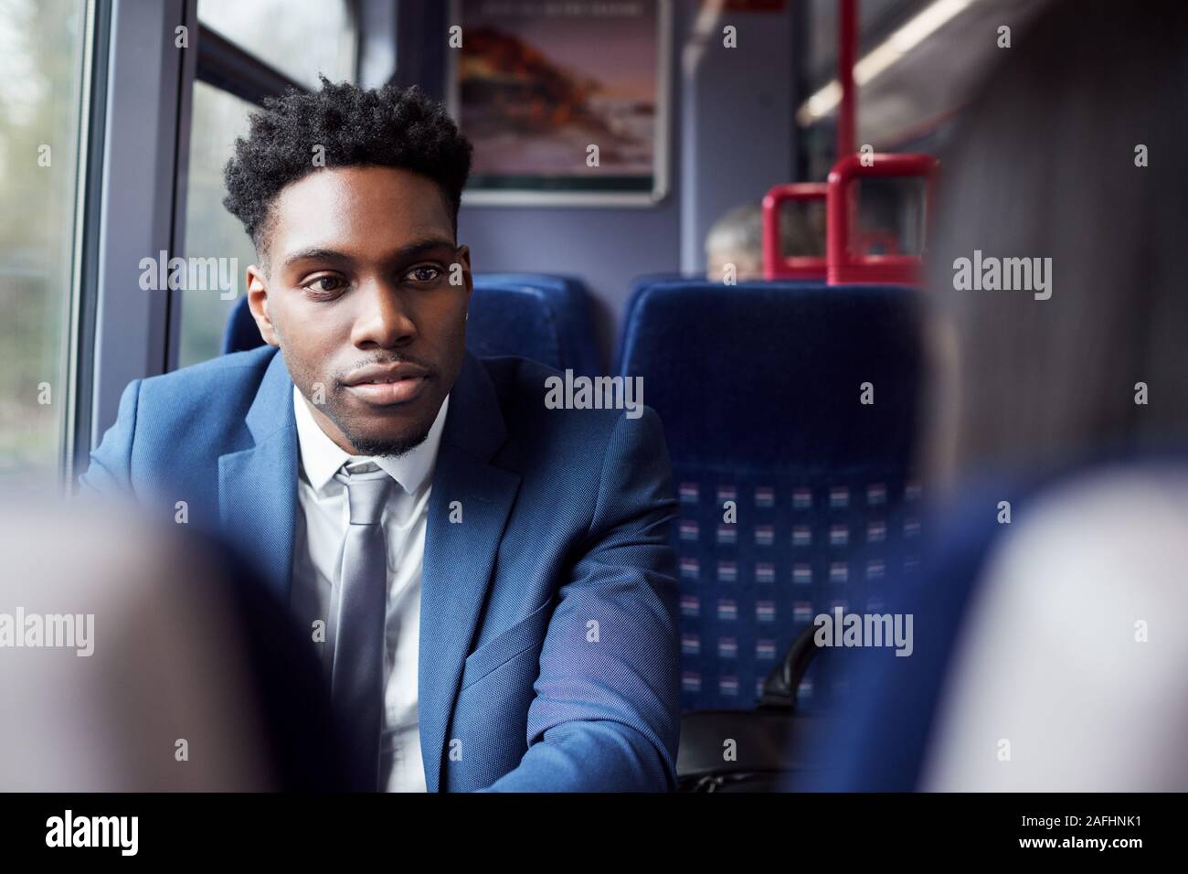 Business i passeggeri seduti in treno il pendolarismo a lavorare avendo discussioni Foto Stock