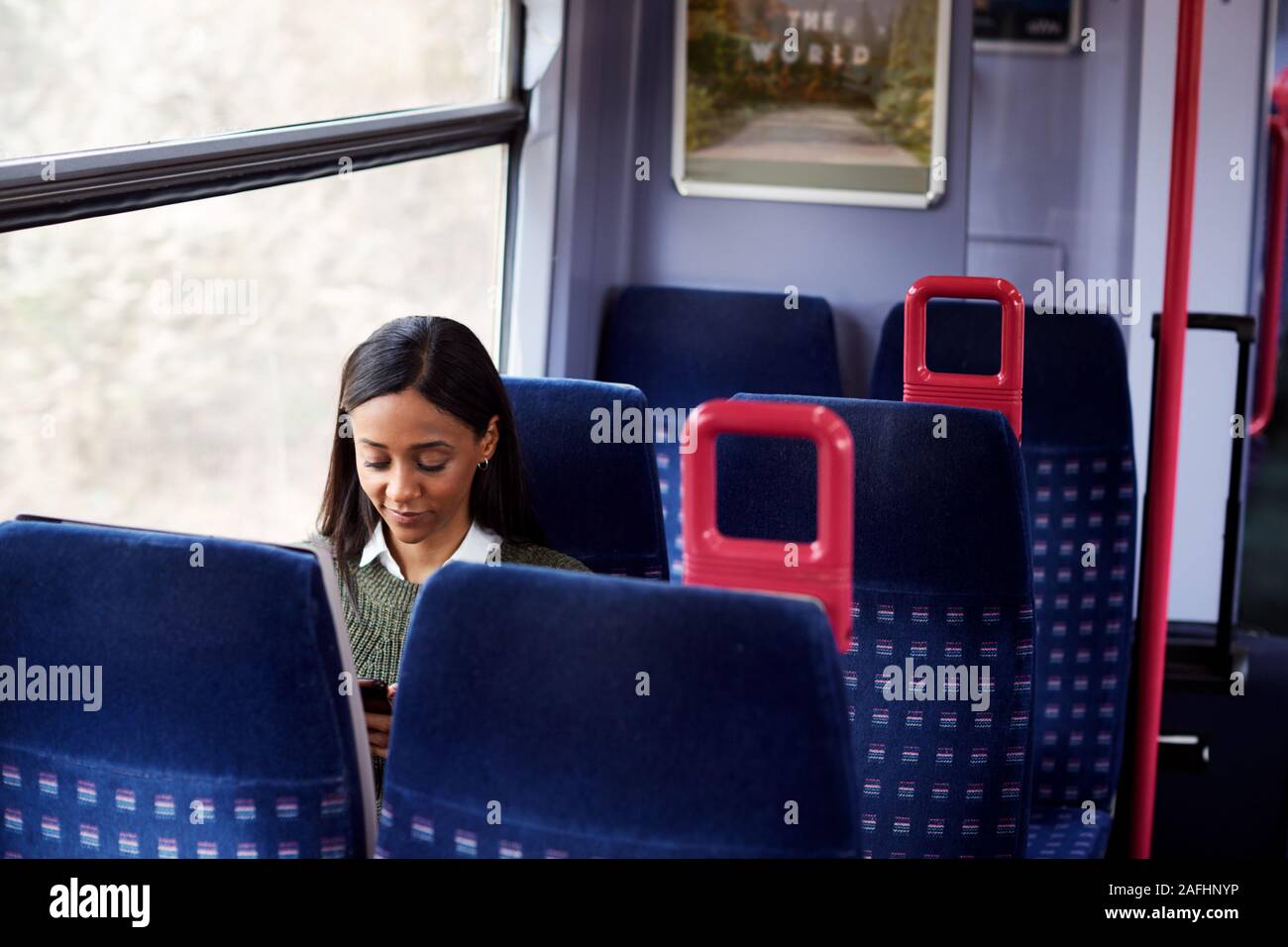Donna seduta passeggero In treno guardando al telefono cellulare Foto Stock