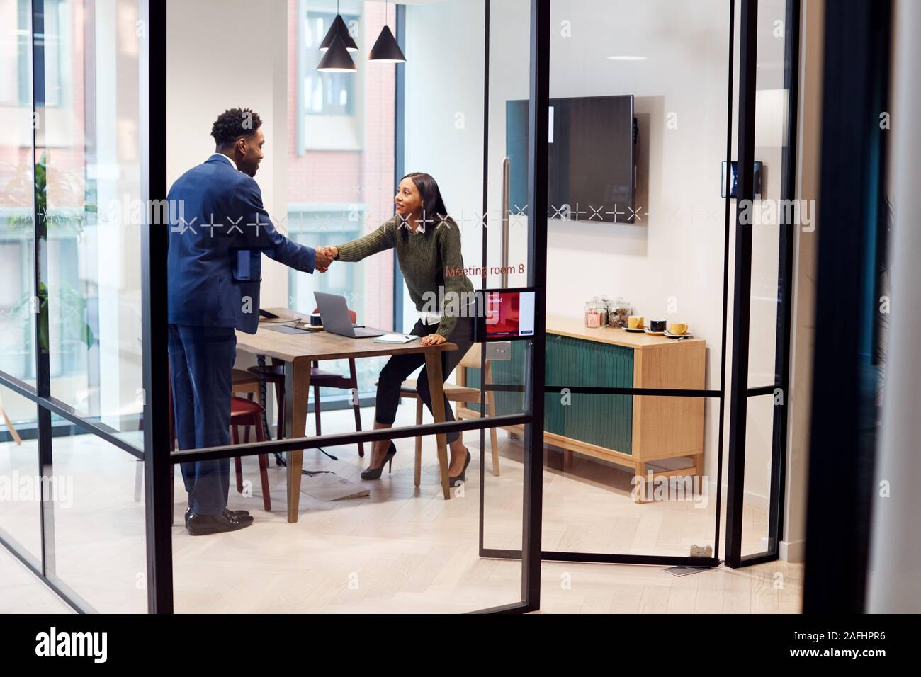 Imprenditrice stringono le mani con maschio Candidato al lavoro in sala riunioni dopo il colloquio Foto Stock