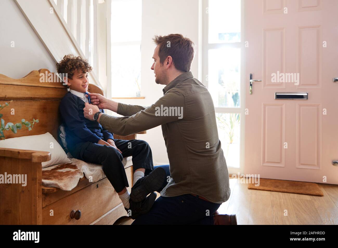 Unico padre a casa Getting figlio indossando divisa pronto per il primo giorno di scuola Foto Stock