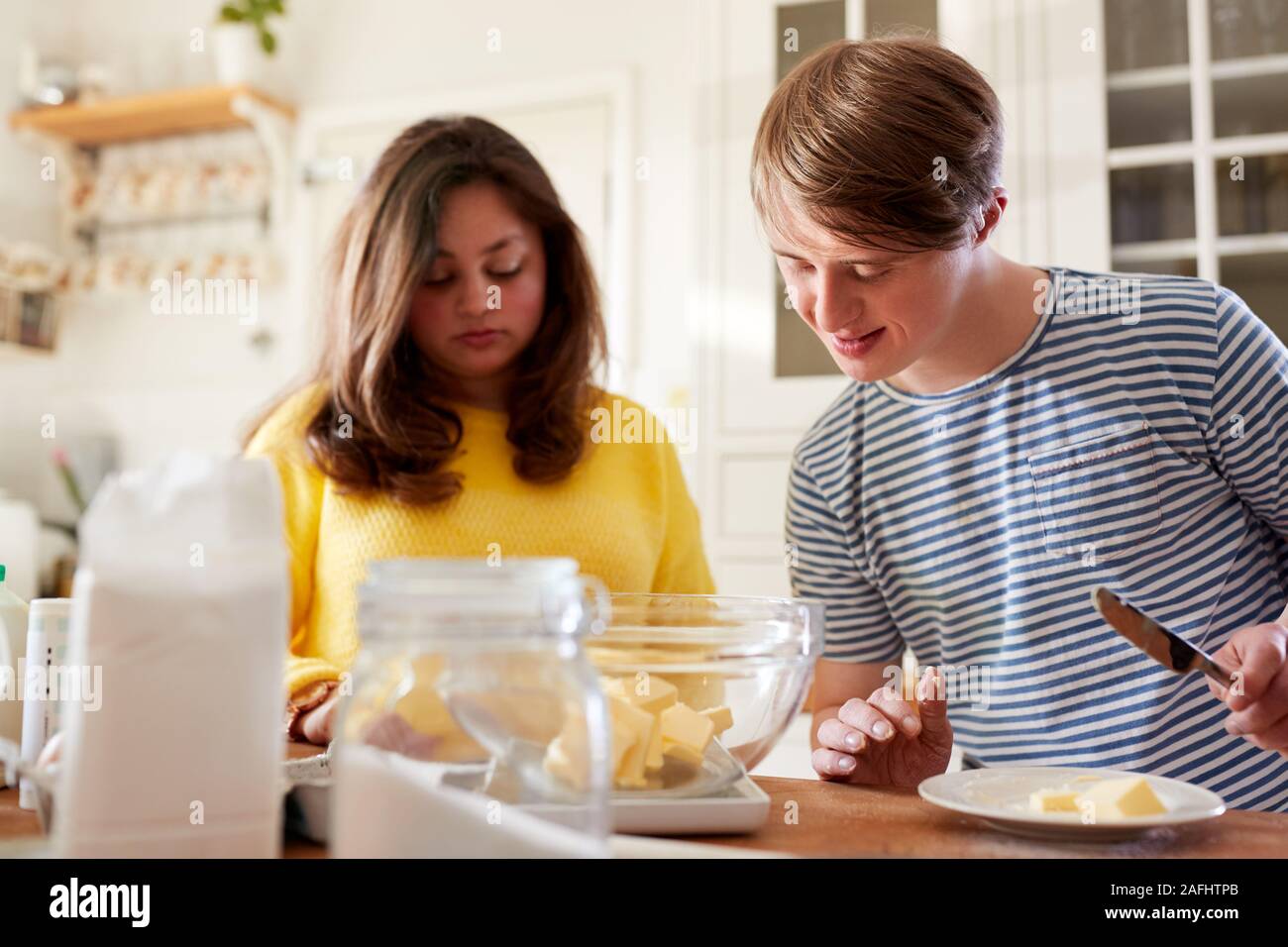 Giovani sindrome Downs matura la cottura in cucina a casa Foto Stock