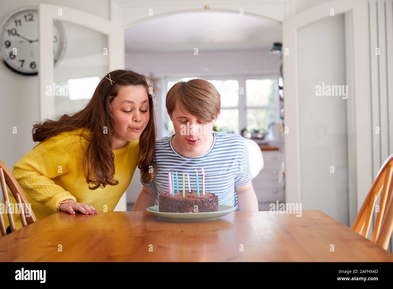 Giovani sindrome Downs giovane festeggia il compleanno a casa con torta Foto Stock