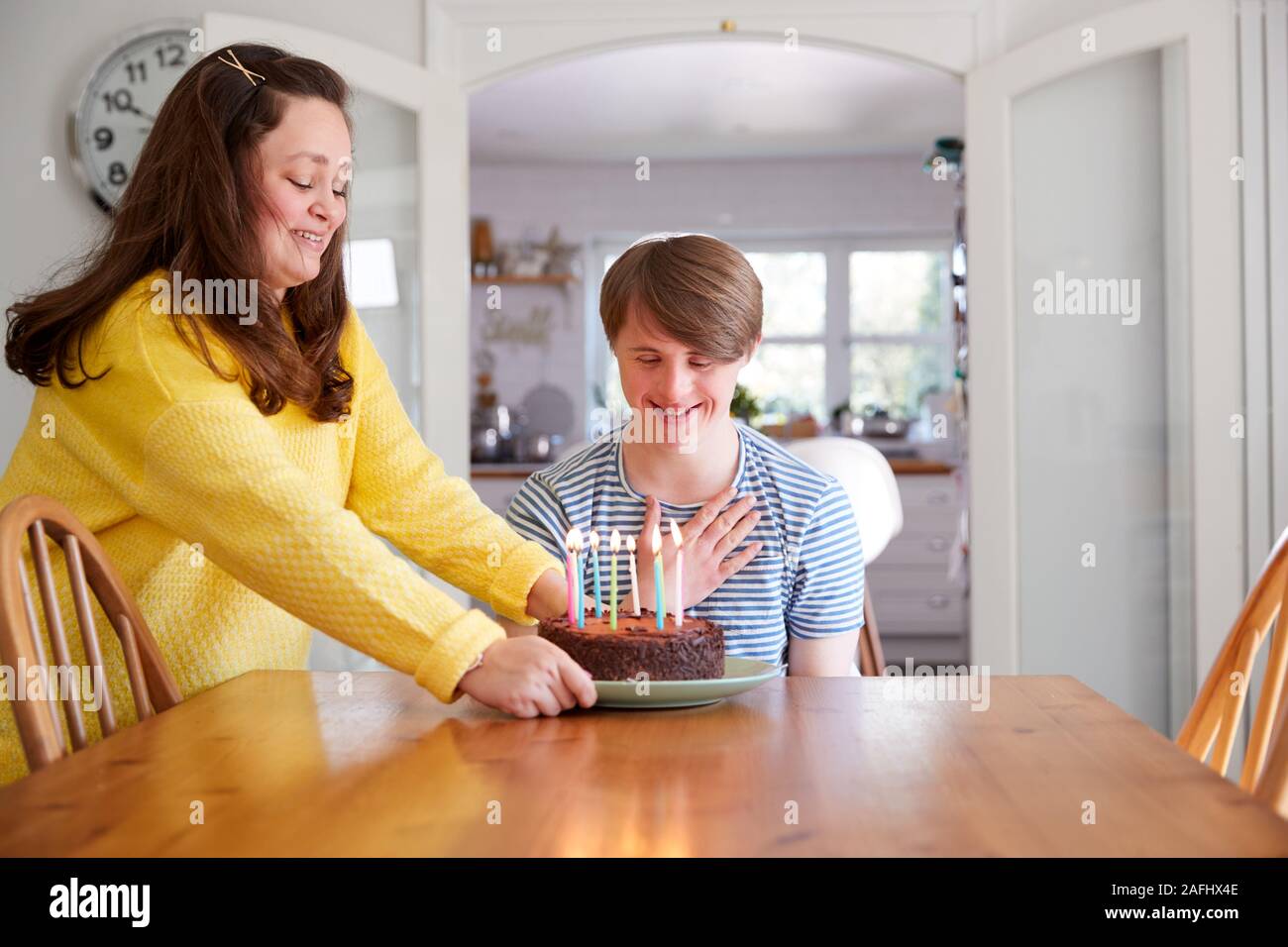 Giovani sindrome Downs giovane festeggia il compleanno a casa con torta Foto Stock