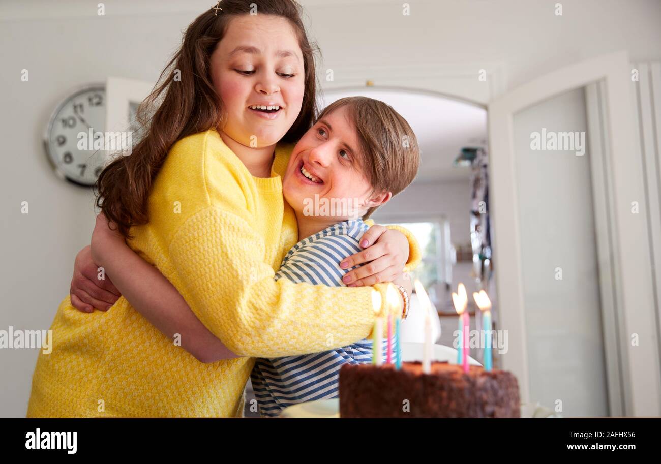 Giovani sindrome Downs giovane festeggia il compleanno a casa con torta Foto Stock