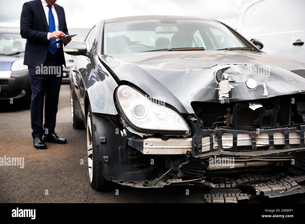 Maschio perdita di assicurazione con regolatore digitale compressa ispezione di danni alle auto da incidente del motore Foto Stock